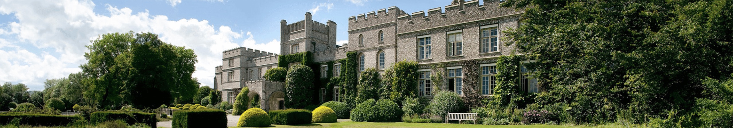 An image of a prestigious looking school surrounded by lots of greenery and trees.